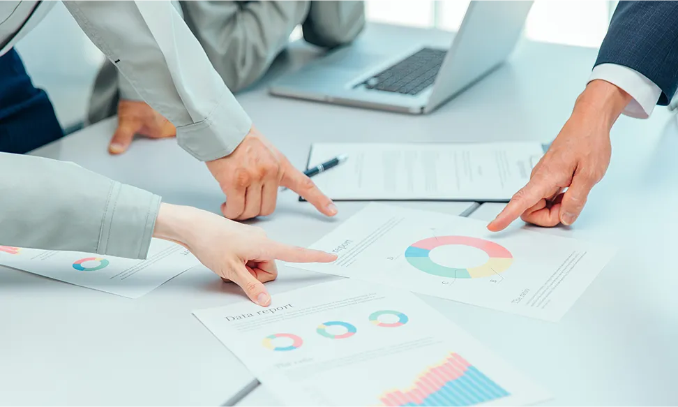 A photo pointing to the data on the desk during a meeting